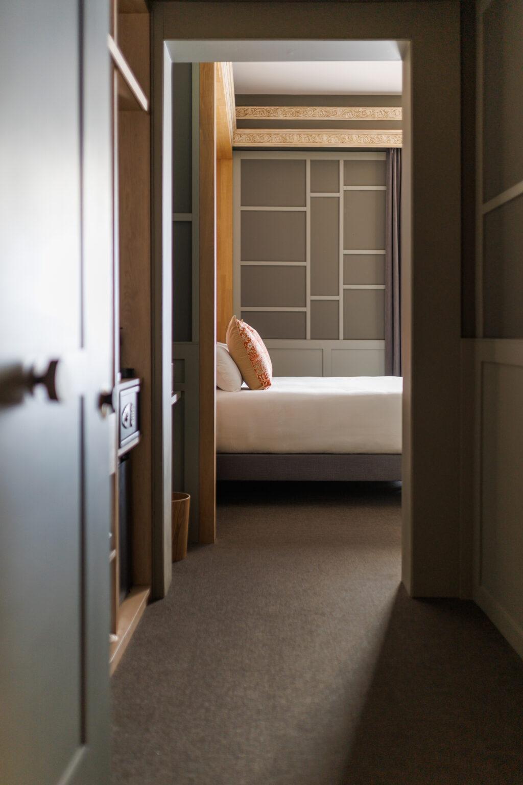 Diseño interior de habitación con iluminación natural y materiales cálidos.