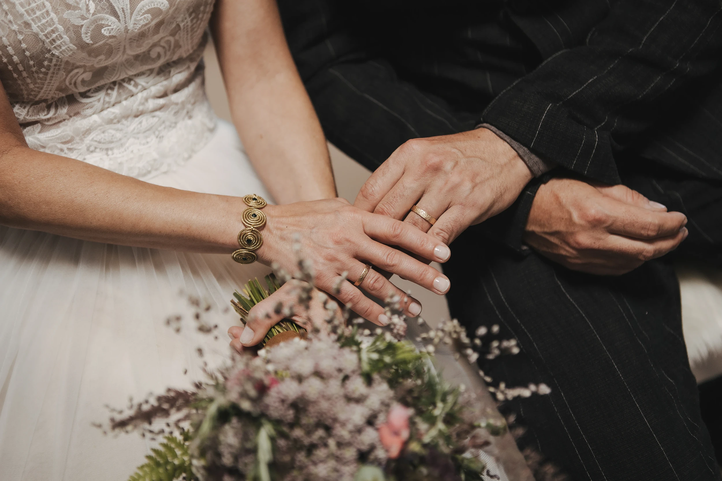 Hände eines Hochzeitspaares mit Eheringen in Südtirol